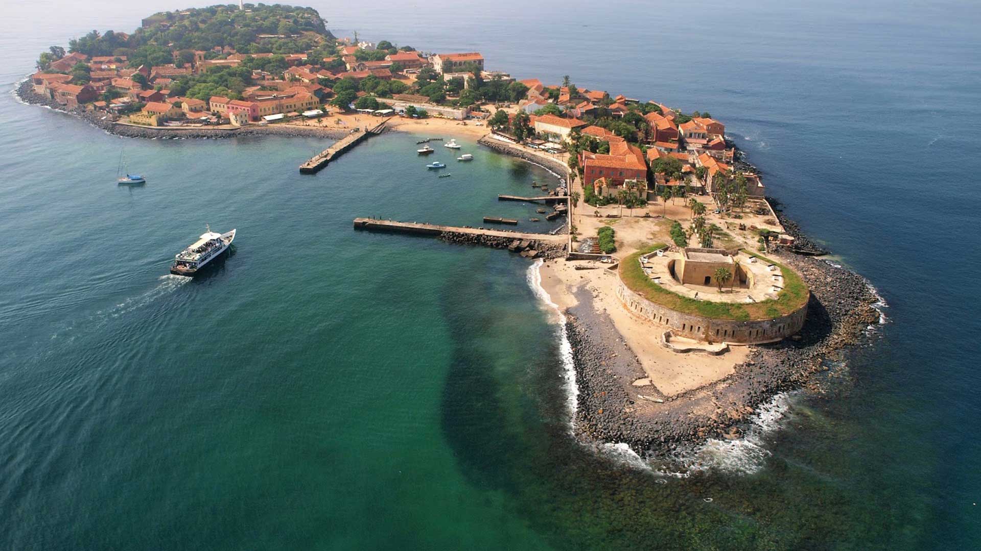 Dakar et l’île de Gorée, lieu symbolique de l’histoire de l’esclavage Charmante petite île au large de Dakar, avec ses maisons pastel et ses innombrables restaurants, devenue un lieu touristique incontournable du Sénégal de par son rôle durant la traite des esclaves.